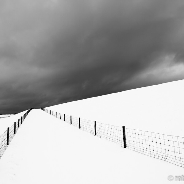 Een dreigende sneeuwbui boven de waddendijk op Texel.