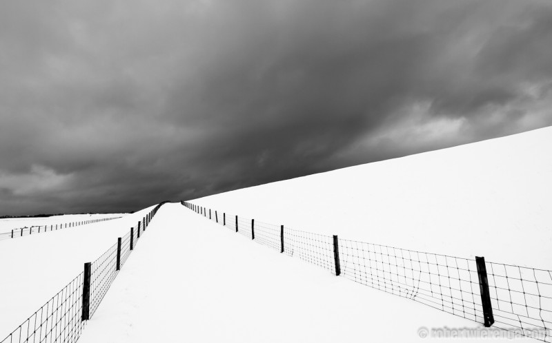 Een dreigende sneeuwbui boven de waddendijk op Texel.